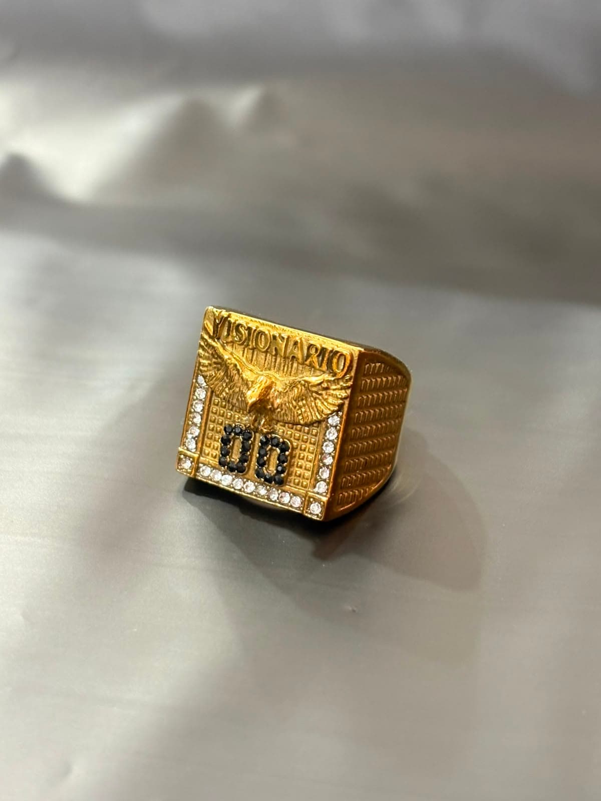Anel Dourado Visionário com Águia Número 00 Cravejado com Pedras Pretas e Brancas